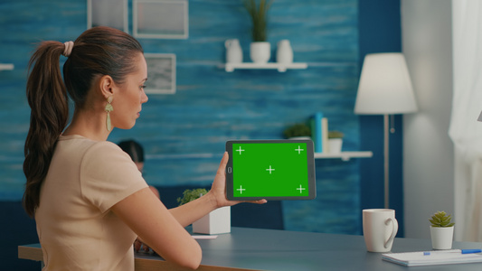 妇女看平板电脑用绿色屏幕模拟视频