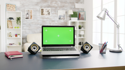 桌上有绿色屏幕的现代笔记本电脑视频