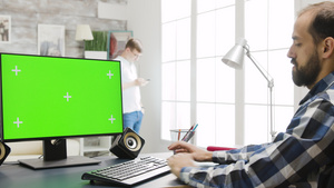 在舒适明亮的客厅用绿色屏幕显示Pc工作的人18秒视频
