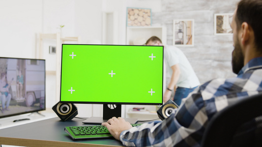 在绿色屏幕上打字的男子镜头缩放缩放pc视频