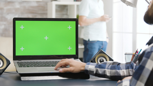 在明亮和光亮的生活空间中的绿色屏幕笔记本电脑视频