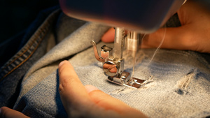 4k关闭一名妇女缝纫用缝纫机修补蓝色牛仔裤7秒视频