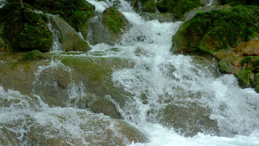 山溪的岩石上流水瀑布中的自然河流景观森林中层层形成视频