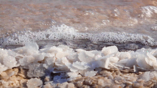 盐湖盐晶体湖水的海浪冲刷着岸边自沉淀的盐分乌克兰库视频