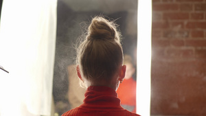 美发师使用发胶为美容工作室的年轻女子固定卷发发型师16秒视频