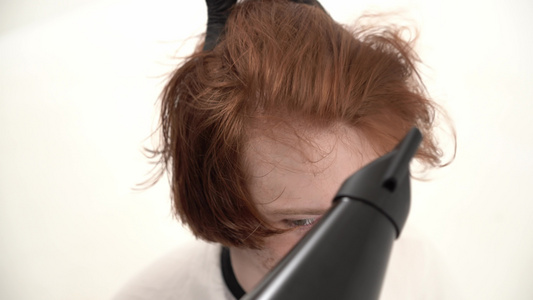 发型师理发师让一个有红头发的时髦发型的年轻人视频