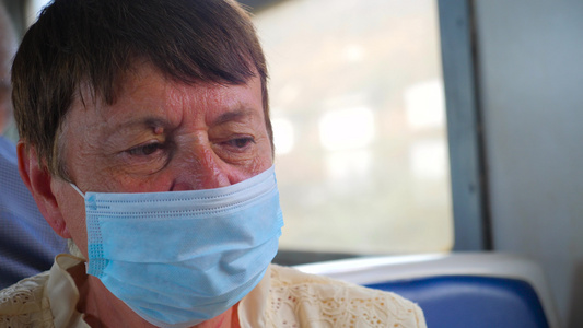 戴着面罩防护面罩的疲惫疲惫的老妇人在公共交通工具上视频