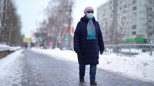 身戴医疗面罩的老年妇女正在街上行走视频