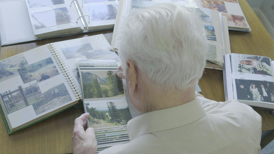 一位年长男子在翻旧相册时的顶部视图视频