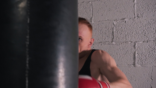 穿着拳击手套训练的肌肉发达的拳击手在白砖墙背景上踢视频