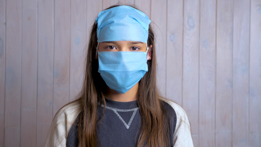 一个美丽的黑发女学生的肖像额头上戴着防护性医疗面罩视频