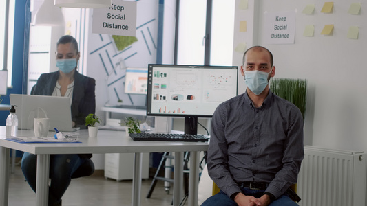 商人在新开办公司办公室时佩戴保护面罩的商家肖像照片视频
