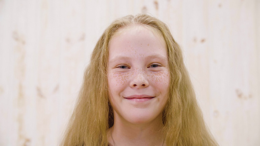 肖像快乐红头发的女孩脸上有雀斑在光工作室对着镜头微笑视频