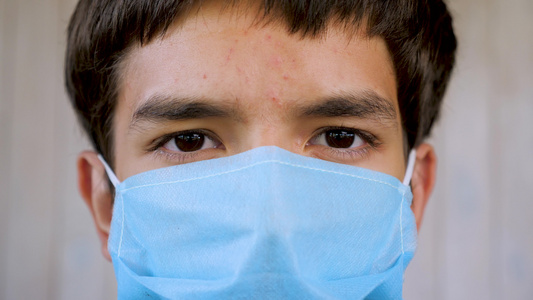 年轻人戴着蓝色医用口罩看着镜头的特写戴防护面罩的病人视频