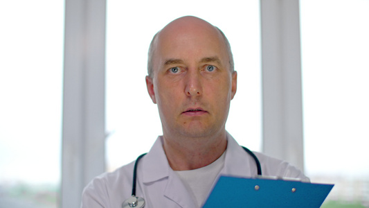 肖像男医生要求病人在诊所填写医疗表格执业医生在医疗视频