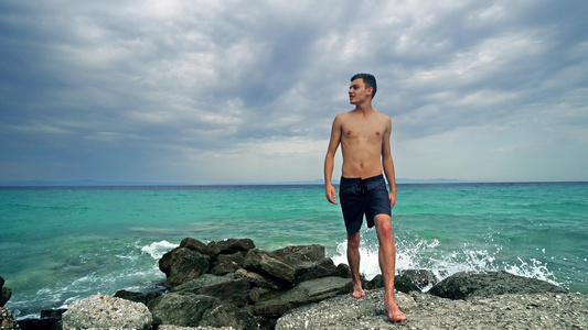 快乐的年轻健康青少年在岩石上行走在海洋前享受假期视频