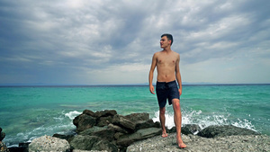 快乐的年轻健康青少年在岩石上行走在海洋前享受假期10秒视频