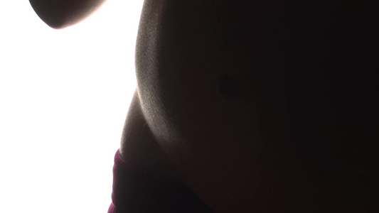 孕妇在怀孕9个月后转身展示肚子准备以白色背景背面环形视频