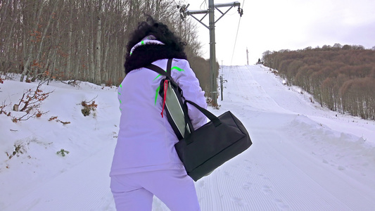妇女步行在陡峭的滑雪坡上视频
