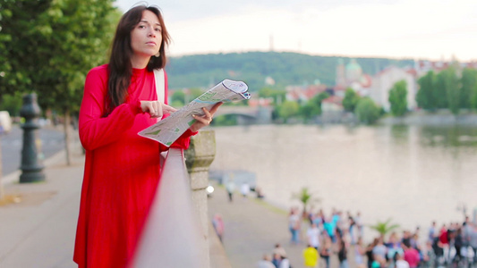 有一张城市地图的愉快的少妇在欧洲背景著名桥梁在欧洲视频