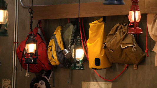 彩色旅游背包挂在墙上并用旧式灯笼挂在墙上视频
