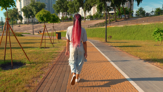 女性在户外漫游城市景背景的阳光下活动视频