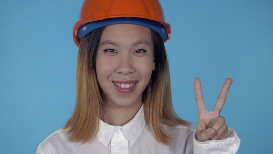 美丽的韩国快乐的建筑工展示出胜利的手势视频