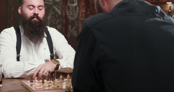 和朋友在酒吧下棋的英俊长胡子男视频