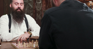 和朋友在酒吧下棋的英俊长胡子男15秒视频