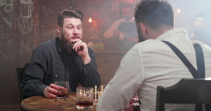 两个年轻的嬉皮士喝着威士忌杯酒在酒吧的棋局比赛中喝酒18秒视频