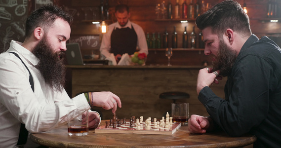 两个有时髦胡子的朋友在酒吧玩象棋游戏的视频