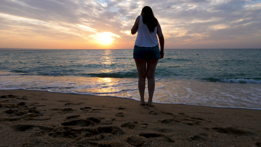 日出时在海滩上的女人视频