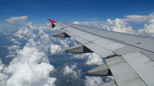 镜头乘飞机旅行通过飞机窗口的鸟瞰图翼飞机和美丽的白云视频