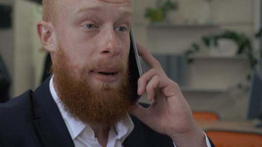 使用智能电话进行商务会谈的胡子男视频