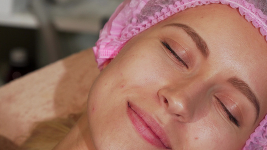 在美容沙龙接受面部治疗的年轻女青年视频