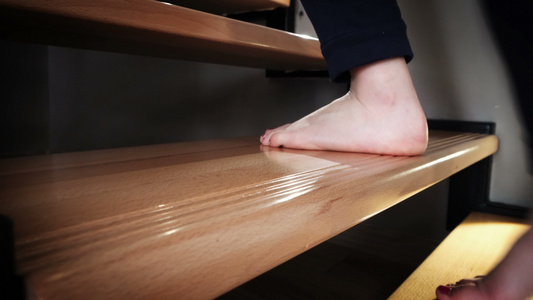 一个十几岁女孩的双腿紧紧合着在家走在豪华的木制楼梯视频