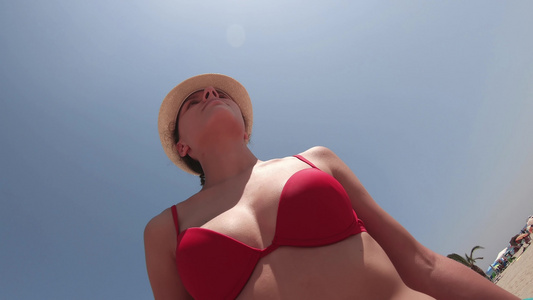 在阳光明媚的日子里戴着帽子在热带海滩散步的美丽的西班牙视频
