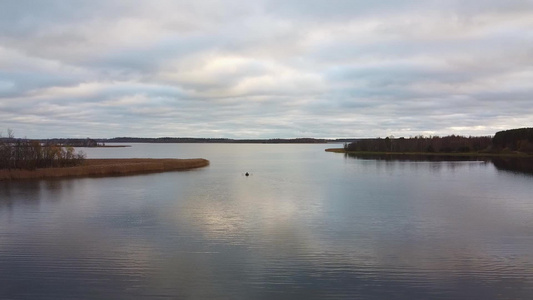 一艘载有渔民的渔船在秋天清晨钓鱼的空中观光景象视频