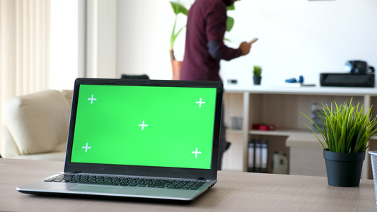 客厅桌上的膝上型电脑带有绿色屏幕和跟踪标记视频