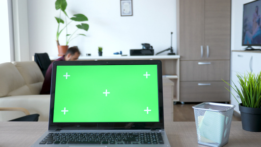 一台带有绿色屏幕模型的笔记本电脑坐在桌子上视频