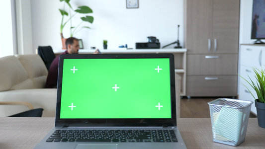 在客厅中间上面有绿色的手提笔记本电脑和绿屏幕染色体视频
