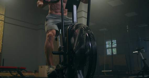 一个男人在健身房里以慢动作主导有氧运动在固定自行车视频