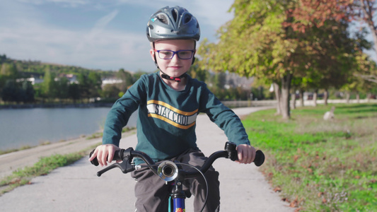 在阳光明媚的秋天小孩在湖边骑自行车视频