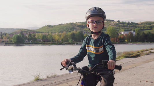 在阳光明媚的秋天小孩在湖边骑自行车视频