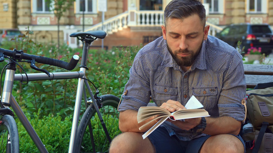 骑自行车者在长椅上读书视频