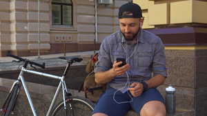 自行车骑行者在街上看智能手机9秒视频
