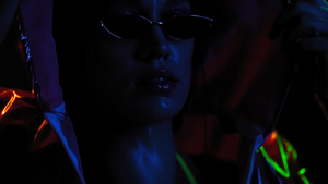 霓虹灯工作室现代女孩在黑色背景上移动慢动作穿着霓虹灯32秒视频
