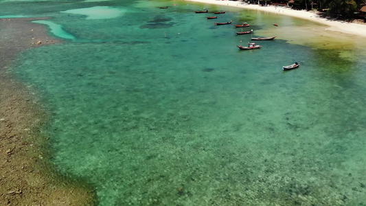 在热带异国天堂岛的白沙海岸附近漂浮在平静的蓝水上的视频