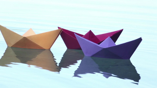 三艘在水上漂浮的彩色纸船视频
