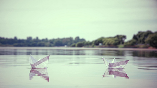两艘小纸船漂浮在水面上视频